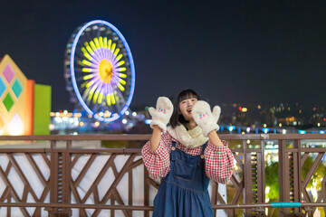 台湾台北市士林区にある遊園地で夜に遊ぶ２０代の若い台湾人女性A young Taiwanese woman in her 20s playing at night at an amusement park in Shilin District, Taipei City, Taiwan