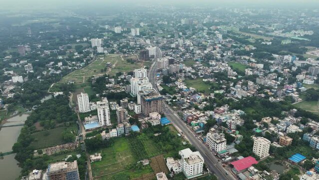Aerial perspective of Rajshahi city in Bangladesh, nestled by the serene banks of the Padma River. Marvel at its vibrant urban landscape, rich heritage in this captivating drone footage. 4k