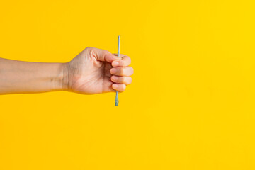 A screwdriver tools in hand on yellow background