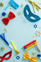 Festive frame of Purim essentials: Top view vertical religious signs, celebration items including masquerade masks and noisemakers, arranged on calming blue background, with space for text insertion