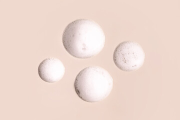 foam cosmetic smears round drops on a beige background