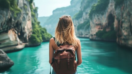 Obraz premium A young woman stands with her back and admires the view of the azure sea and mountains. A person traveling on vacation in the most beautiful place in the world
