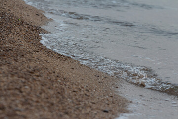 Sea waves on the sandy beach. Selective focus. Shallow depth of field