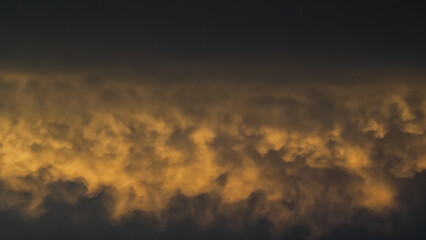 Ciel jaunâtre pendant le coucher du soleil, sous des nuages de type mammatus, après un orage - obrazy, fototapety, plakaty