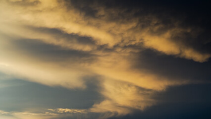 Ciel jaunâtre pendant le coucher du soleil, sous des nuages de type mammatus, après un orage