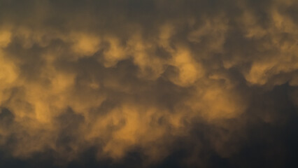 Ciel jaunâtre pendant le coucher du soleil, sous des nuages de type mammatus, après un orage