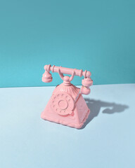 Vintage telephone, rotary dial model, elegant decoration on blue background.
