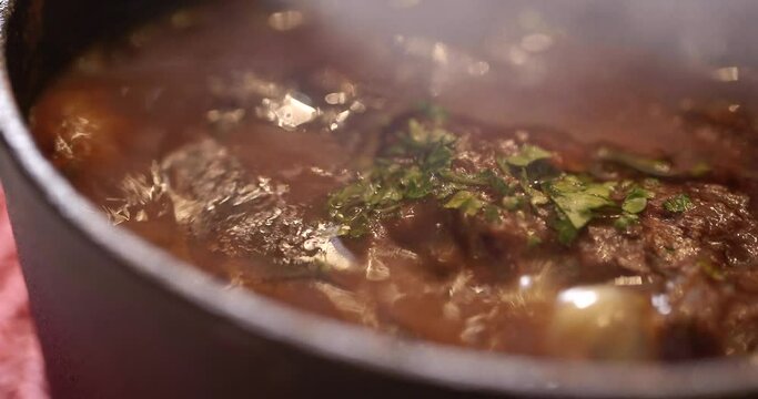 湯気をあげてグツグツ煮立ち湯気をあげるシチューの入った熱い鍋のアップ　マクロ・レストラン・料理・スープ
