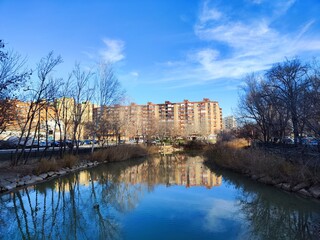 Obraz premium Río con cielo y edificio al fondo en invierno.