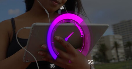 Image of purple speedometer over midsection of biracial woman using tablet