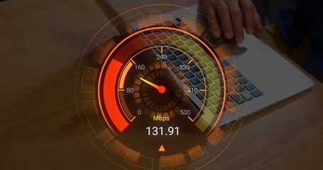 Image of orange speedometer over hands of biracial man using laptop