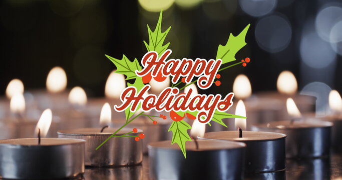 Image of happy holidays text over lit tea candles background