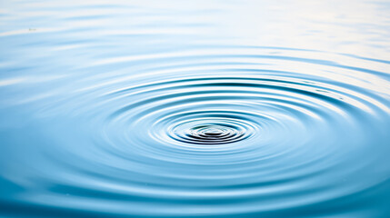 A single droplet of water creating ripples on a serene lake surface