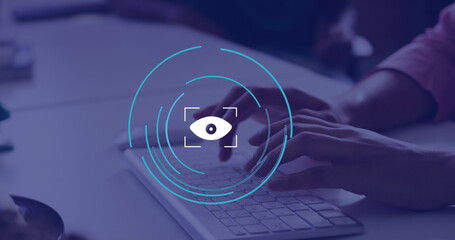 Image of eye icon over hands using computer in office