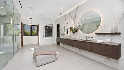 Spacious bathroom with dual sinks, a walk-in shower, and elegant mirrors