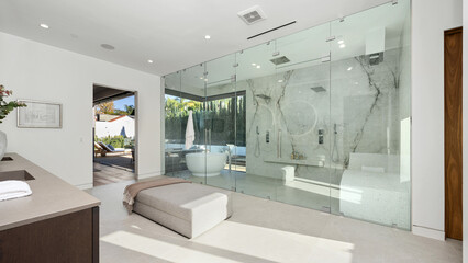 Spacious bathroom with a bathtub behind glass panels