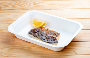 Sea bass fillet. Healthly food. Takeaway food. On a wooden background.