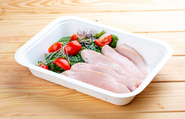 Turkey sous-vide with vegetables. Healthy food. Takeaway food.  On a wooden background.