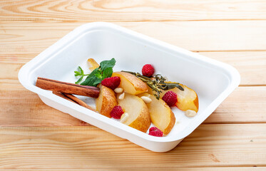 Stewed pear in spices with nuts. Healthy food. Takeaway food.  On a wooden background.