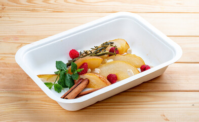 Stewed pear in spices with nuts. Healthy food. Takeaway food.  On a wooden background.