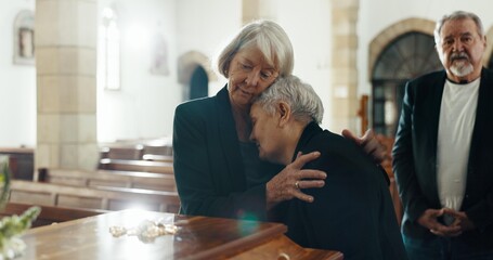 Senior women, coffin and funeral in church for memory, support and condolences with religion with...