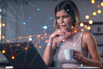 Fototapeta na wymiar Thoughtful businesswoman in casual wear typing on laptop at office workplace with coffee cup. Concept of distant work, business, internet surfing, information technology. Social network hologram