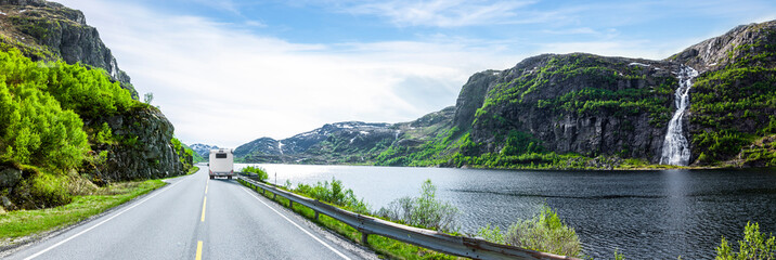 Camper auf einer Uferstrasse an einem See mit Wasserfall in Norwegen © by-studio
