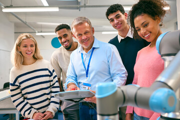 Group Of College Or University Engineering Students In Robotics Class With Male Teacher