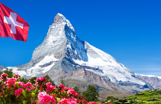 Berggipfel Matterhorn mit Schweizer Fahne und Alpenrosen