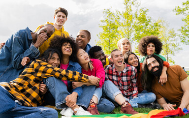 Self portrait of multiracial group of young student friends sitting on campus