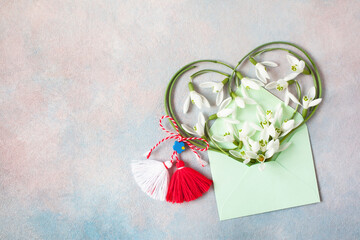 Decorative background with snowdrop flowers in the shape of a heart in an envelope and a symbol of...