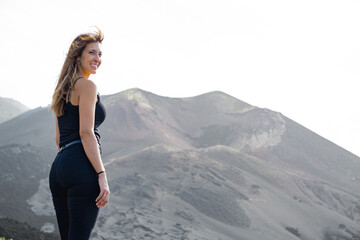 standing woman smiles from the viewpoint of a volcano in La Palma
