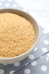 Brown sugar in bowl on table, closeup