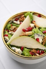 Delicious pear salad in bowl on light table, closeup