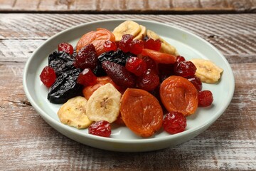 Mix of delicious dried fruits on wooden table, closeup