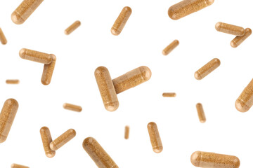 Vitamin. Many capsules falling on white background