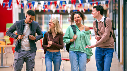 Group Of University Students With Bags Socialising In College Building