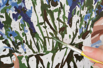A photo of a picture that is colored by numbers in the process of coloring with a brush