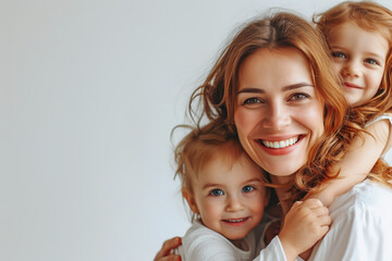 Glückliche, lächelnde Mutter mit ihren beiden Kindern vor hellem Hintergrund
