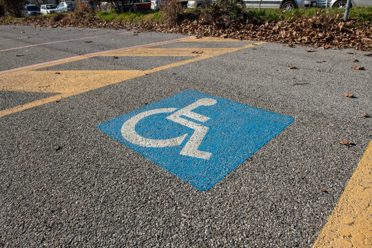 parking for disabled people, symbol printed on the asphalt, parking space reserved for cars for disabled people and their companions, road sign