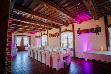Valmiera, Latvia - July 7, 2023 - Rustic banquet hall with festive lights, decorated tables, and a...