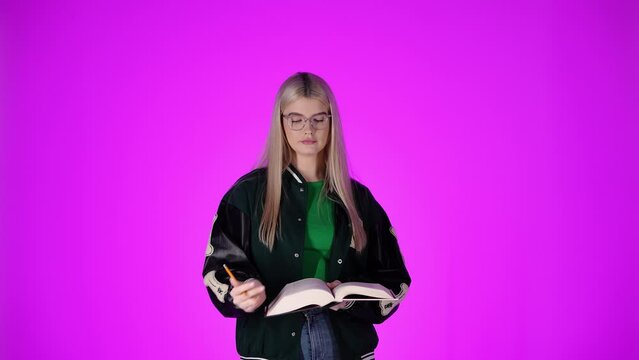 Ładna studentka robi notatki w ksiażce