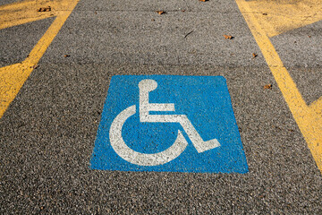 disabled space symbol, parking for disabled people, symbol printed on the asphalt, parking space reserved for cars for disabled people and their companions, road sign