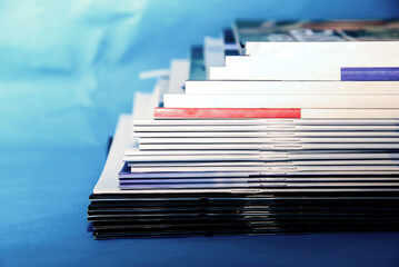 Stack of magazines on blue background. Isolated. Educational concept