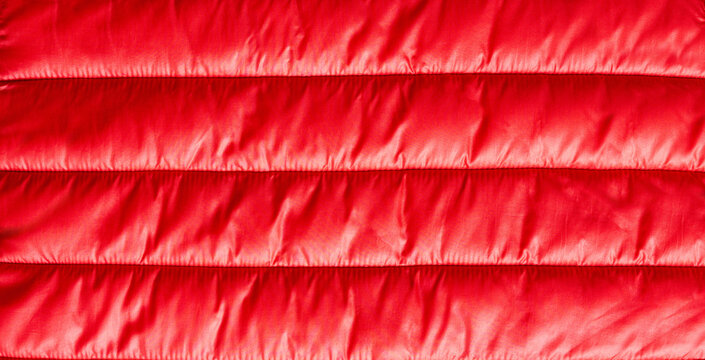Texture of red down jacket fabric close up