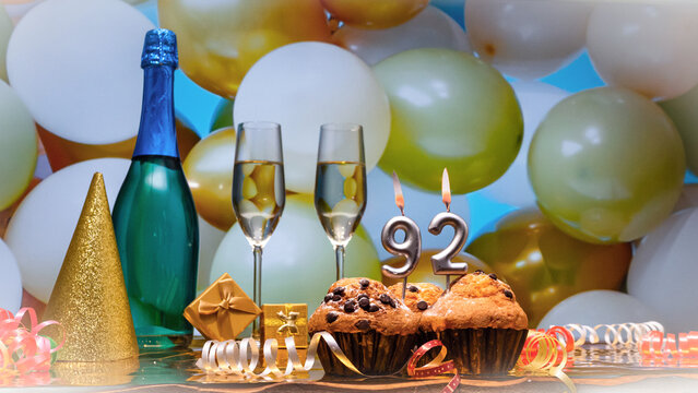 Happy birthday champagne background with number of candles  92. Beautiful congratulations copy space for anniversary..Holiday decorations with balloons with a bottle of champagne in pastel colors.