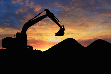 Crawler excavators silhouette are digging the soil in the construction site. on the sunset ...