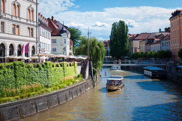 tourist ferry sailing upstream in the center of the old town of Ljubljana 