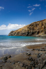 Rugged rocks merging with black sand.