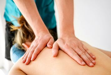 Fototapeta na wymiar Massage therapist doing back massage in spa Salon. Healthcare and relaxation procedures.